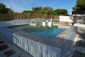 uma piscina num quintal com uma cerca de madeira em La Estrella - piscina privada em Chiclana de la Frontera