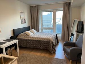 um quarto com uma cama, um sofá e uma janela em ARENA Studio em Tampere