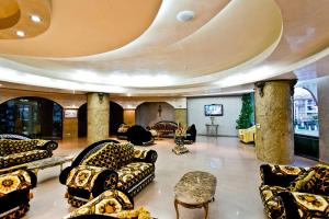 a lobby with couches and tables and a television at Saint George Palace Hotel in Sveti Vlas