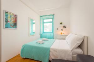 a white bedroom with a bed and a window at Mimi in Pula