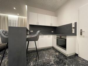 a kitchen with white cabinets and a chair in it at Exklusive Wohnung in Linz