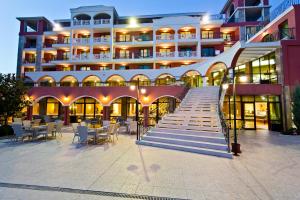 a large building with stairs and tables and chairs at Saint George Palace Hotel All-inclusive in Sveti Vlas