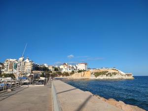 a sidewalk next to the ocean with buildings in the background at Apartamentos Casa May II - Centro Benidorm in Benidorm