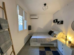 niewielka sypialnia z łóżkiem i oknem w obiekcie Tiny Little House w Atenach