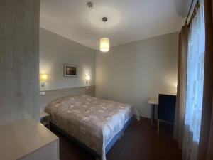 a small bedroom with a bed and a window at Vila Claudia in Palanga