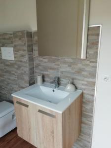 ein Badezimmer mit einem weißen Waschbecken und einem Spiegel in der Unterkunft Suite Centrale 44 in Marsala + 8 Fotos