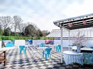 een patio met blauwe en witte stoelen en tafels bij Cat Villa - Vacation STAY 12826 in Fukizua
