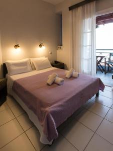 a bedroom with a large bed with two towels on it at Anesis Hotel in Agios Ioannis Pelio
