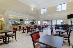 a restaurant with tables and chairs and a bar at Comfort Suites La Porte in La Porte