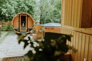 a wooden cabin with a gazebo in a yard at Duch Huszczy w środku sosnowego lasu in Łomazy