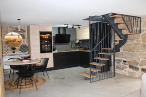 a kitchen and dining room with a spiral staircase at CASA VACACIONAL ACIO in Ourense