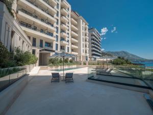 a balcony of a building with chairs and an umbrella at CASA AL MARE RESIDENCE in Bečići