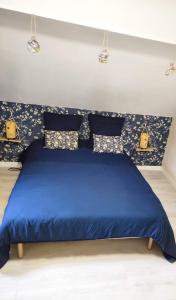 - un lit bleu dans une chambre avec des draps bleus dans l'établissement Zoologîte, à Saint-Aignan