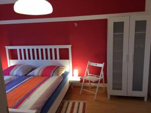 um quarto com uma cama e uma parede vermelha em Petersweitblick-Bayerischer Bahnhof em Leipzig