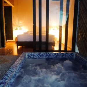 eine Badewanne in einem Zimmer mit einem Bett im Hintergrund in der Unterkunft Suite Pacandé , cerca al desierto de la tatacoa in Aipe