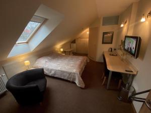 a bedroom with a bed and a desk with a chair at Vila Claudia in Palanga