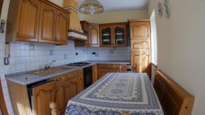 a kitchen with wooden cabinets and a sink and a table at Casa di 2 piani ai piedi della Valtournenche CIR 0032 in Châtillon