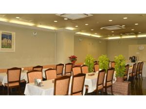 a dining room with tables and chairs and plants at Pulsesin in Kyoto - Vacation STAY 73549v in Kyoto
