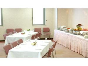 une salle à manger avec des tables, des chaises et un tissu de table blanc dans l'établissement Pulsesin in Kyoto - Vacation STAY 73552v, à Kyoto