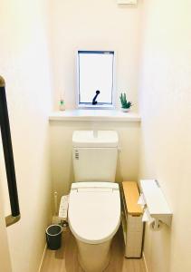 ein weißes WC im Bad mit Fenster in der Unterkunft Yatsugatake Villa Masaki - Vacation STAY 74331v in Hokuto
