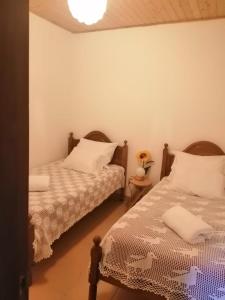a bedroom with two beds with white sheets at As três irmãs in Bragança