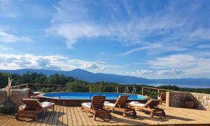 eine Terrasse mit Liegestühlen und einem Pool in der Unterkunft Stone House Rosuja in Ivanje