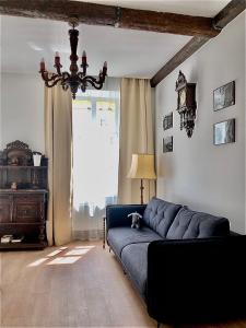 sala de estar con sofá azul frente a una ventana en Apartments Galicia en Leópolis