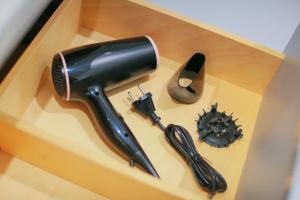 un sèche-cheveux et une brosse à cheveux dans une boîte en bois dans l'établissement La Montgolfière, T2 hypercentre chic et cosy, Wifi par SOVALFI, à Saint-Étienne