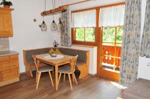 a kitchen with a table and chairs and a window at Ferienwohnung Maria Erlsbacher in Sankt Veit in Defereggen +13 photos