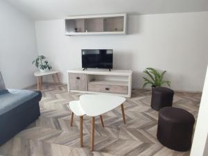 a living room with a television and a table and stool at Apartman Flora Vrdnik in Vrdnik