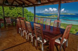 einen Holztisch und Stühle mit Meerblick in der Unterkunft VILLA DOMINGO - Incroyable vue panoramique in Andilana