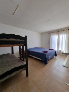 ein Schlafzimmer mit einem Bett und einem Etagenbett in der Unterkunft Maipu Alquiler Por Dia in Río Gallegos