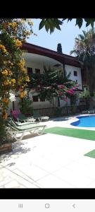 een huis met stoelen en een zwembad ervoor bij Kaleiçi Ozkavak Hotel in Antalya