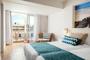 una habitación de hotel con una cama y un balcón en Playa Park Zensation, en Corralejo