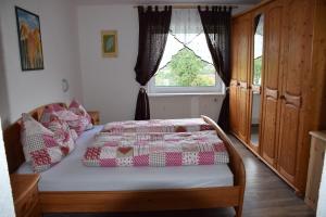 a bedroom with a bed with a quilt on it at Harmonie Stüberl in Ottnang am Hausruck