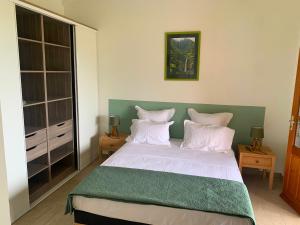 um quarto com uma cama grande e almofadas brancas em GITES CASUARINA em Sainte-Rose