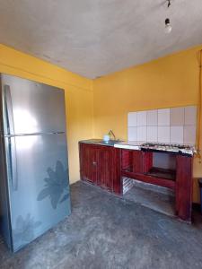 een keuken met een koelkast en een gele muur bij Casa De Descanso Cuautla Morelos in Cuautla Morelos