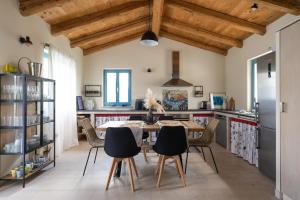 kuchnia z drewnianymi sufitami oraz stołem i krzesłami w obiekcie Villa Toro w mieście Motovun