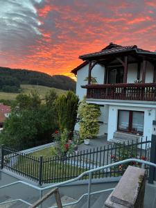uma casa com uma varanda com um pôr-do-sol em Haus Martina em Lutter