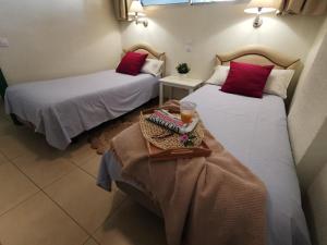 two beds in a hotel room with a tray of food at Cherry Top Cake Apartment in Playa del Ingles