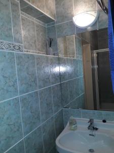 łazienka z umywalką, toaletą i lustrem w obiekcie Flamingo Apartman w mieście Sopron