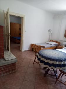Habitación con cama, mesa y sillas. en Flamingo Apartman, en Sopron
