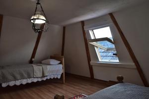 - une chambre avec 2 lits et une fenêtre dans l'établissement Casuta din dumbrava, à Ocna Şugatag
