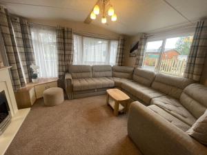 a living room with a couch and a table at Two Bedroom Caravan at Lilliarsedge in Jedburgh