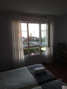 a bedroom with a bed and a large window at Hotel Restaurante el Fornon in Novellana
