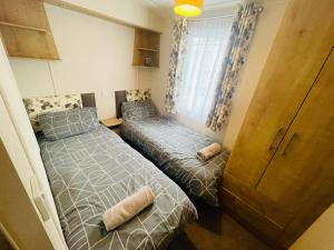 um quarto com 2 camas e uma janela em Two Bedroom Caravan at Lilliarsedge em Jedburgh