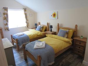 a bedroom with two beds and a window at The Feed Room At Eastmoor Farm Fully Renovated Fully Equipped 2 Bed Luxury Mews Cottage 1 Mile from the Beach in Bridlington