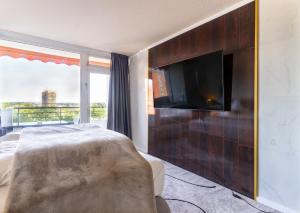 a bedroom with a flat screen tv on a wall at GelsenDesign III - Netflix I Balkon I Zentral in Gelsenkirchen