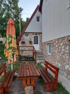 a picnic table and an umbrella next to a building at TARA BUNGALOV in Žabljak