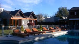 a row of chairs sitting next to a swimming pool at Mediterráneo Cabañas in Chascomús